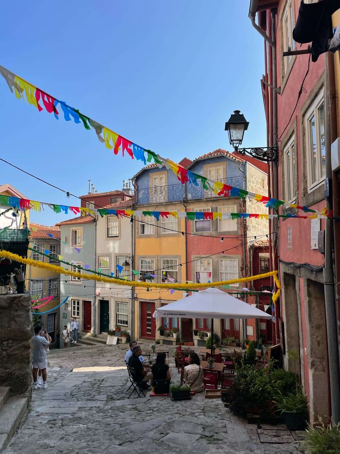 A stepped lane of colourful houses strung with festival bunting in Porto's Ribeira